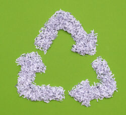 Recycle,symbol,made,from,heap,of,shredded,white,paper,over